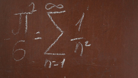 Textured brown chalkboard background. A formula, equation is written on the board with a piece of...