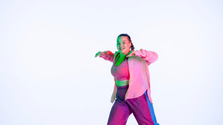 Attractive woman dancing jazz-funk on white isolated background in a studio. Blue and pink...