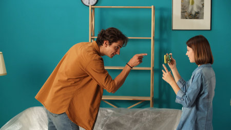 Close up shot of apartment living room. Woman recording video on smartphone of man in new apartment room.の写真素材