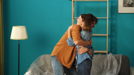Close up shot of apartment living room. Man and woman in the new apartment room hugging each other, happy mood.の写真素材