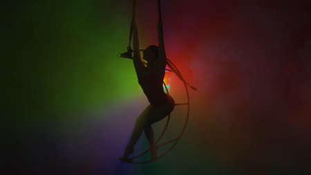 Rhythmic gymnastics girl performs the scum on one arm in the air on a metal rotating structure moon.の写真素材