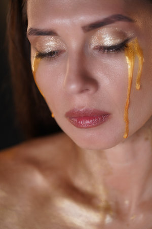 Portrait of brunette female model in studio.. Attractive woman with makeup looking down from camera...