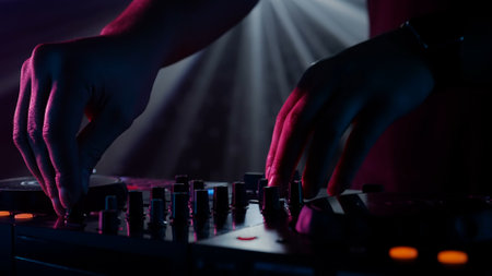 DJs Hands Adjusting Sound Mixer Under Club Lightsの写真素材