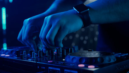 DJs Hands Adjusting Sound Mixer Under Club Lightsの写真素材