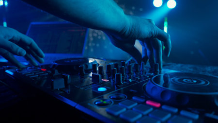 DJs Hands Adjusting Sound Mixer Under Club Lightsの写真素材