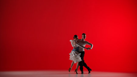 Elegant Ballroom Dance Couple on a red backgroundの写真素材