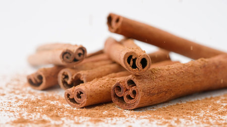 Close up studio shot of food ingredient. A pile of brown dried cinnamon sticks laying on the white background.の写真素材