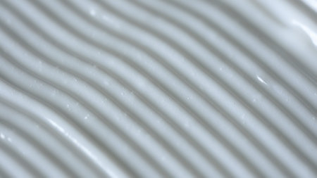 Beauty and skin care products advertisement creative concept. Close up shot of cream background. Face or body white cream fluid texture with strokes. Smooth moisturizer cream shot.の写真素材