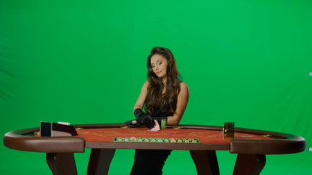 Elegant female in studio on chroma key green screen. Attractive woman in black dress at the...