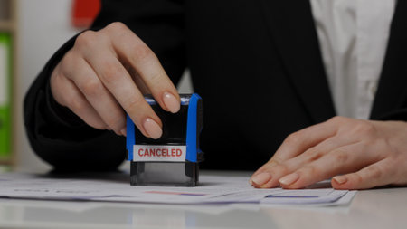 Close up shot of person visa application. Top view of usa visa document, female worker puts stamp with canceled mark written on it.の写真素材