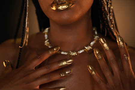 Portrait of an African-American woman with a gold necklace around her neck. The models lips, fingers...