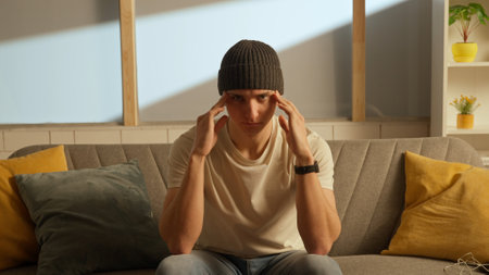 Human emotion creative concept advertising. Portrait of a distressed young man in a room sitting on...