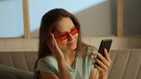 Music and human emotions creative advertisement concept. Woman in red glasses and earphones on the...