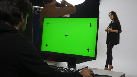 Backstage of model and professional team in the studio. Close up of editor at chroma key green...