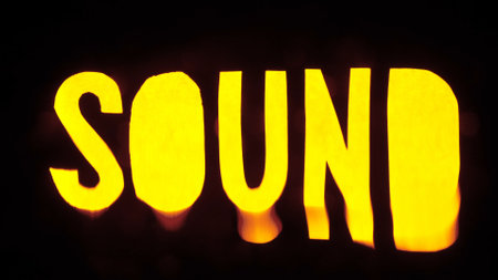 Text sign template isolated on black background. Word sound glowing yellow in darkness with water waves moving over text with ripples and splashes.の写真素材