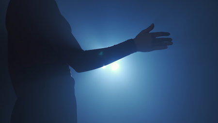 Female model against bright backlight on black smoky background in studio. Female silhouette, moving...