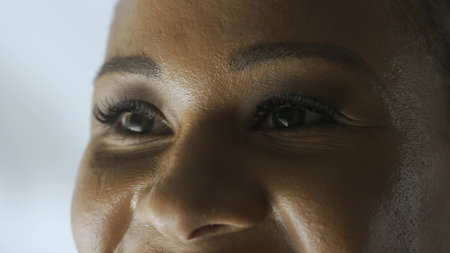 Macro shot of female model face. African American woman shot cropped face, green eyes looking away from camera.の写真素材