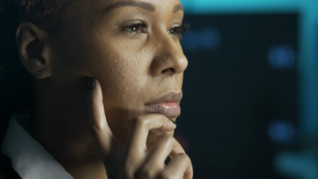 Close up shot of female working at office. African American business woman looking at monitor, analyzing data on screen, concentrated focused face expression.の写真素材