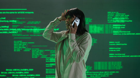 IT specialist against big digital screen. Woman engineer arguing talking on smartphone in front of the screen with digital code error processの写真素材