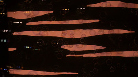 Soap bubbles on a black background with pink stripes