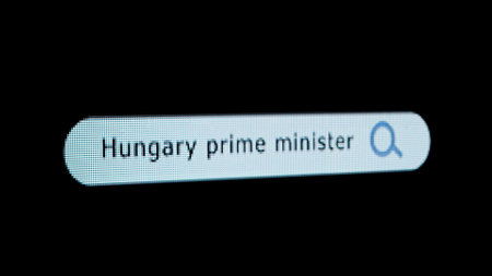 Shot of monitor screen. Pixel screen with animated search bar, keywords Hungary Prime Minister typed...