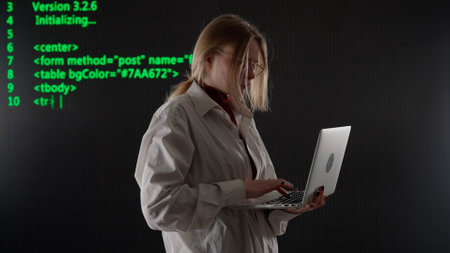 Person against big digital wall in studio. Woman hacker with laptop hacking server database, digital...