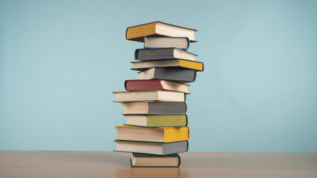 Colorful Pile of Books Against a Pastel Blue Backgroundの写真素材