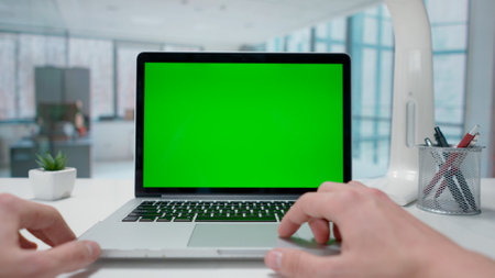Businessman working on laptop with green screen in Office. Advertising area, workspace mock up.