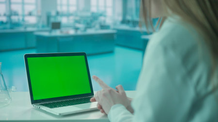 Video Call on Laptop with Green Screen on Research Biochemistry lab Desk. Advertising area, workspace mock up.の写真素材