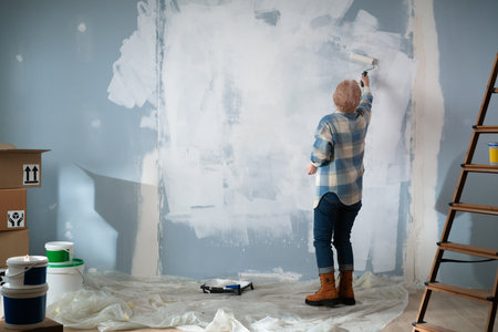 Diligent Senior Woman Painting Walls Back view.の写真素材