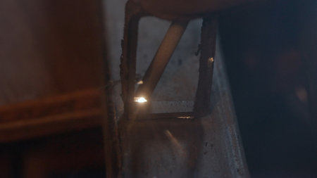 Metalworker using welding machine on iron surface, flame, sparks and flashing lights, close up view...