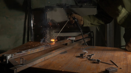 Metalworker using welding machine on iron surface, smoke, sparks and flashing lights around, man...