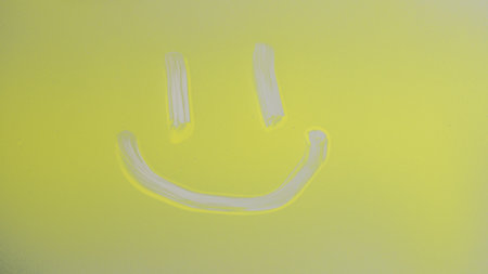 Yellow Smiley Face Painted on Glass Surfaceの写真素材