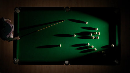 Top view shot of russian billiard green cloth table with red and white balls, person hitting the...