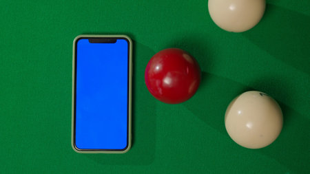 Top view shot of russian billiard green cloth table with smartphone blue screen workspace mockup and...