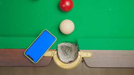 Top view shot of russian billiard green cloth table with smartphone blue screen workspace mockup and...