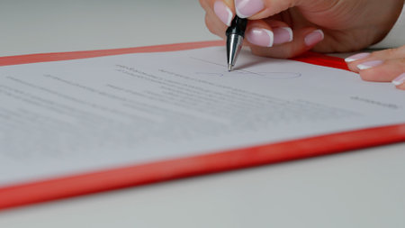 Close up of student hand underlining a document on a desk at home. Highlighter in man hand marked...