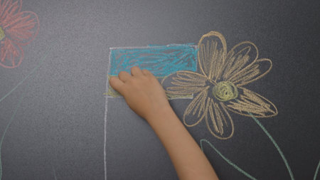 Children doing creative tasks in developmental classes, drawing on chalkboard with colorful chalks. Children education concept.の写真素材