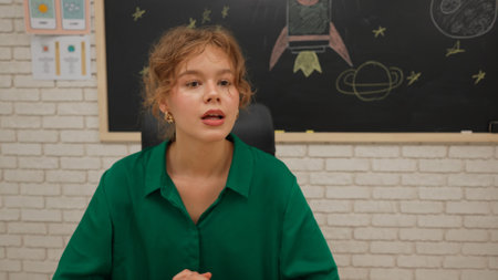 Junior school boys and girls in classroom in astronomy class. Female teacher talks solar system, shows earth card. Modern education concept.の写真素材