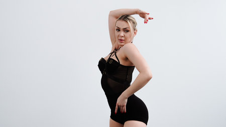 Young woman in black clothes dancing high hills on white backgroundの写真素材