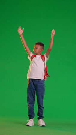 Joyful Schoolboy with Backpack on Green Screenの写真素材