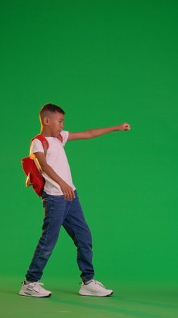 Young Boy Striking a Superhero Pose Against Green Screenの写真素材
