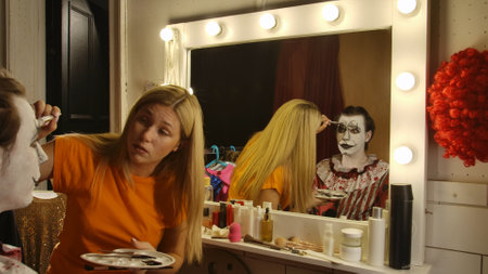 Makeup Artist Applying Clown Makeup for a Halloween Eventの写真素材