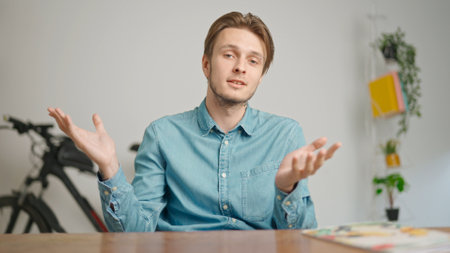 Man college student studying at home, sitting at desk, talking with teacher, answering questions, listening lesson online on computer. Modern online educationの写真素材