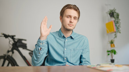 Man college student studying at home, sitting at desk, talking with teacher, answering questions, listening lesson online on computer. Modern online educationの写真素材