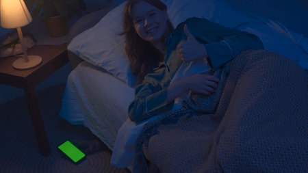 Woman sleeping in bed in apartment room. Scary hand with smartphone chroma key green screen crawls...