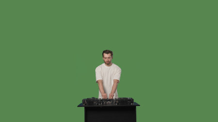 DJ mixing music on a turntable in a studio on a green screen background