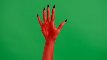 Creepy halloween devil monster hand in red paint with black nails shows open palm, isolated on chroma key green screen background, workspace mockup.の写真素材