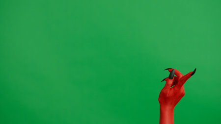 Creepy halloween monster hand in red paint with black nails pointing finger up, isolated on chroma key green screen background, workspace mockup.の写真素材
