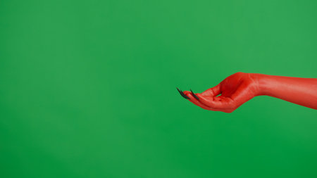 Creepy halloween devil monster hand in red paint with black nails shows cupped palm, isolated on chroma key green screen background, workspace mockup.の写真素材